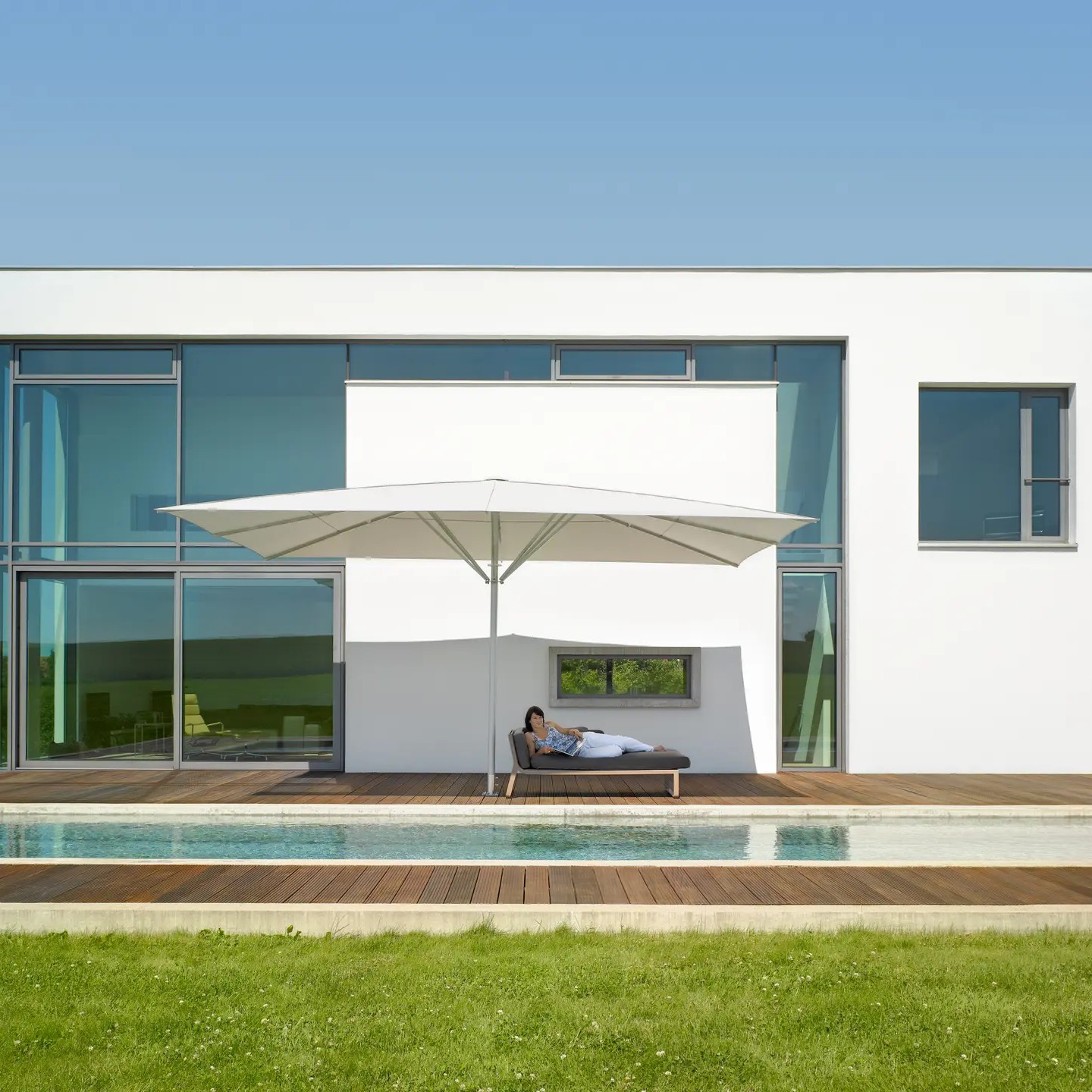 Moderner Sonnenschirm bietet stilvollen Schatten im Garten- und Poolbereich eines luxuriösen Hauses in Berlin.